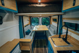 This RV rental's modern interior showcases a kitchen, dining nook, and elevated bed. Ideal for van life exploration.