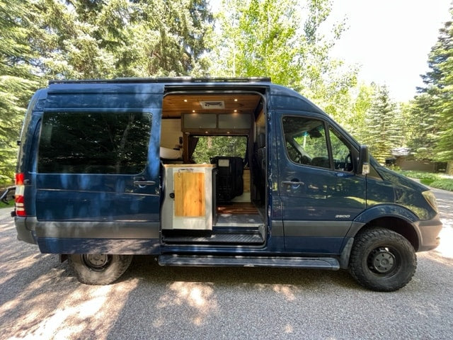  revealing a cozy wood interior.|Tour an rv rental! See this custom camper van's interior: wood walls — photo 5