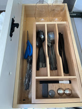 RV rental kitchen drawer, neatly organized with stemless glasses, black utensils, scissors, and a marker in a wooden insert.