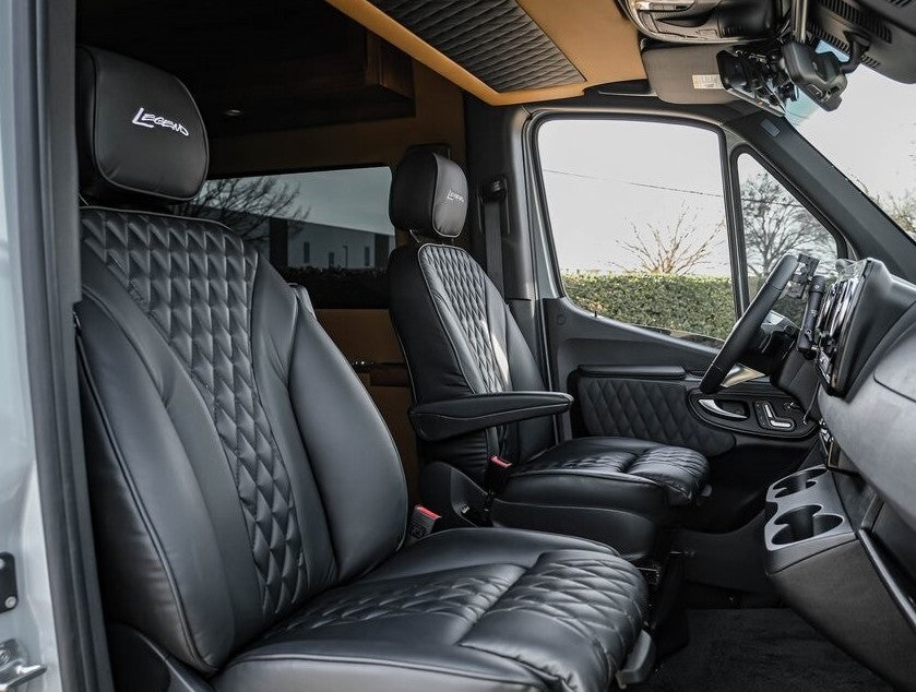 Premium rv rental cab interior featuring plush black quilted leather seats, "Legends" headrests, and a sophisticated design. — photo 9