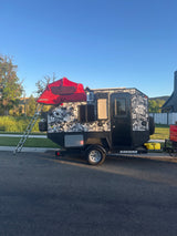 "Karavan" off-road camper trailer with a red rooftop tent, ideal for your next rv rental adventure.