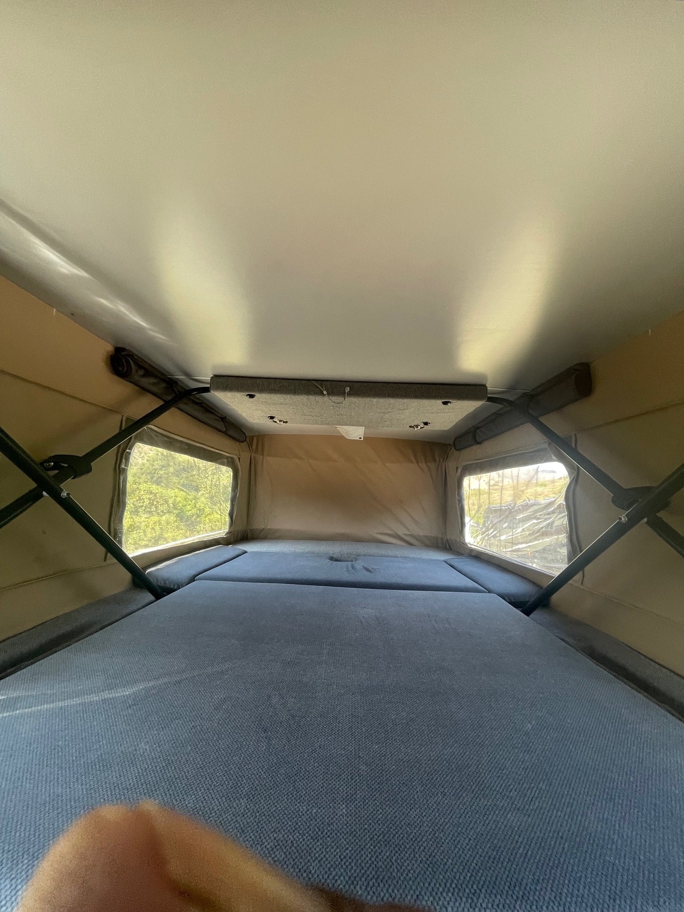 RV rental pop-top interior: cozy beds, large windows with nature views. Ready for adventure camping.