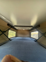 RV rental pop-top interior: cozy beds, large windows with nature views. Ready for adventure camping.