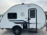 Side view of a white Braxton Creek 15DS travel trailer for RV rental, featuring the "Joy Ride" logo.