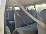 View from inside a passenger van with grey seats and seatbelts, offering a glimpse of an RV rental in the background.