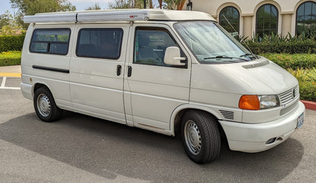 White camper van with awning & high roof, suitable for rv rental. A spacious mobile home for travel.