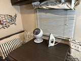 Cozy RV rental interior featuring a table with a small fan, an iron, decorative pillows, and a USA map on the wall.