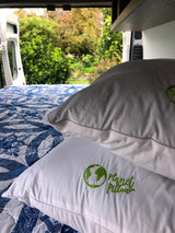 Comfortable RV rental bed with eco-friendly Planet Pillows offers serene views of nature.