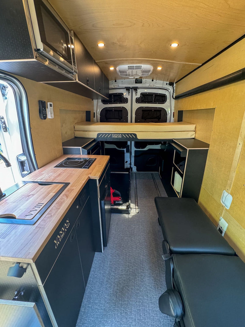  and wooden counter. Ready for travel.|RV rental interior: Versatile black padded seating converts to a bed — photo 15