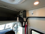 RV rental interior: Overhead storage, phone charging station, and organization hooks for mobile living in a camper van.