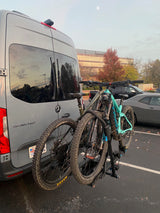 Gray Mercedes Sprinter RV rental with two mountain bikes on a rear hitch rack.