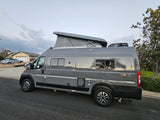 Modern gray Winnebago Solis pop-top RV rental parked curbside, ideal for road trips and camping adventures.