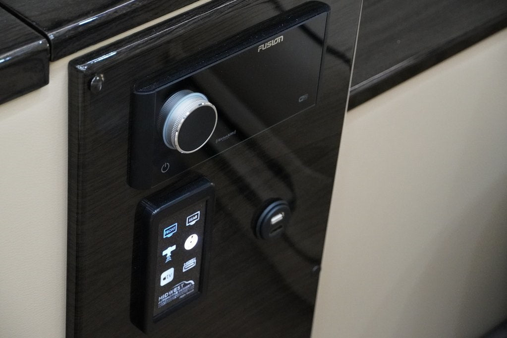RV rental interior control panel: Fusion stereo, light/media smart controls, and USB charging for passenger comfort.