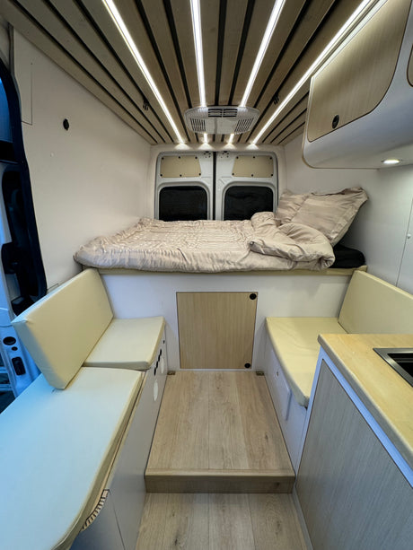 Step inside this clean, modern RV rental. Enjoy the cozy bed, bench seating, and compact kitchen.