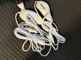 Essential for comfort in an rv rental: tangled white electric blanket controls and cords with a US plug on dark fabric.