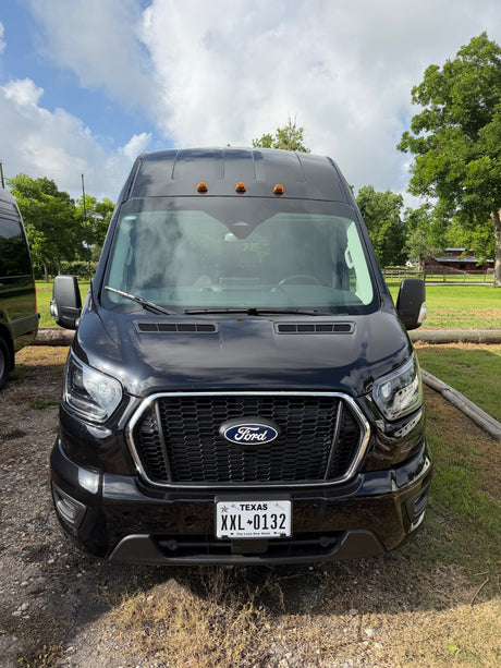 Black Ford Transit van, a spacious RV rental option, parked in a scenic setting. Texas plate XXL-0132 visible.