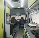 Inside a modern rv rental camper van, revealing the cockpit, a compact kitchen with a sink, and rear seating.