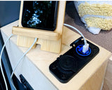 RV rental convenience: Phone charging on a bamboo stand via a 12V USB charger. Essential mobile power for travel.