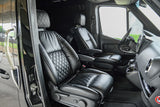 Luxury RV rental interior with custom black leather diamond-quilted captain's chairs and spacious cabin layout.