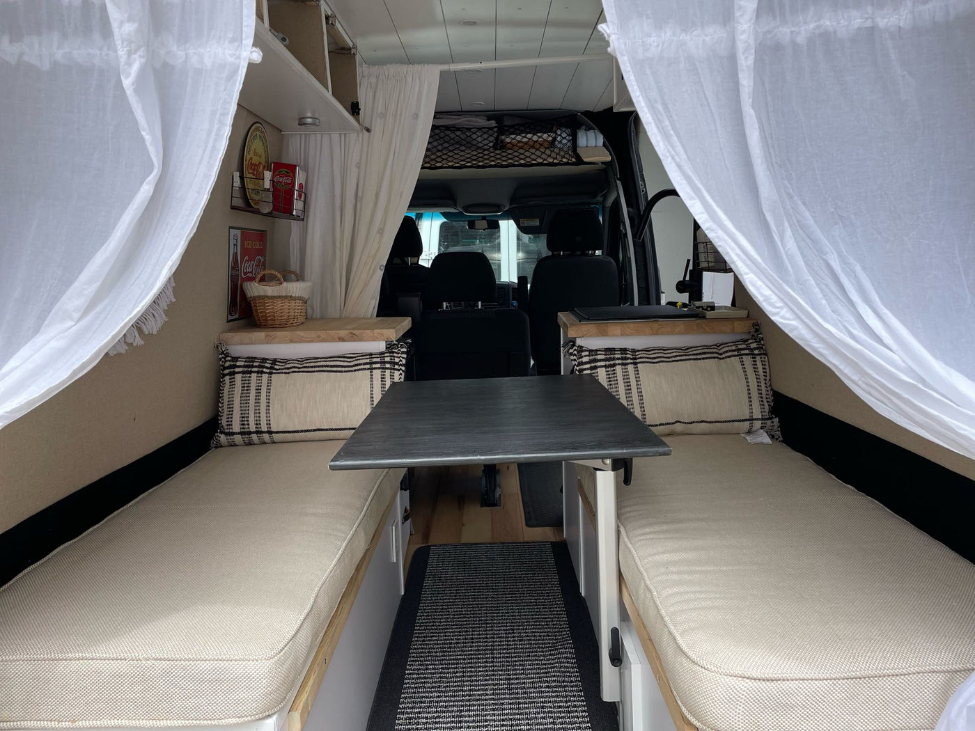Cozy RV rental interior with convertible seating/beds, dining table, and storage. Ideal for comfortable mobile living. — photo 8