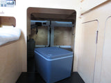 RV rental: Camper van's rear storage features a portable fridge, water jugs, and light wood interior under the bed.