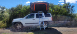 White SUV with a large rooftop tent & ladder, ready for your rv rental camping adventure. Ideal for overlanding!