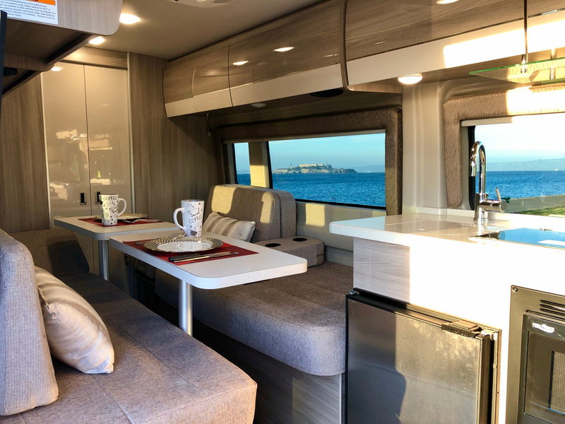 Spacious RV rental interior with a cozy dining area, functional kitchen, and incredible San Francisco Bay views of Alcatraz. — photo 7