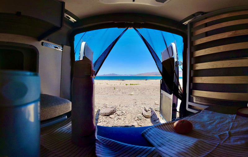  a vast desert road stretches ahead under clear skies with distant mountains.|Overhead RV rental AC unit with cooling vents — photo 14