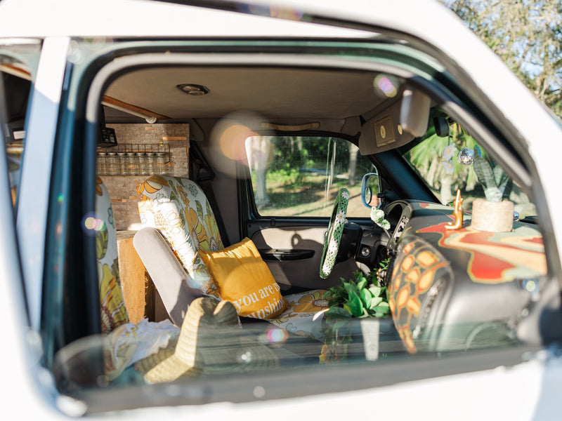 perfect for your next RV rental adventure. Parked outdoors by water.|This cozy RV rental features a decorated interior with a comfortable bed — photo 5