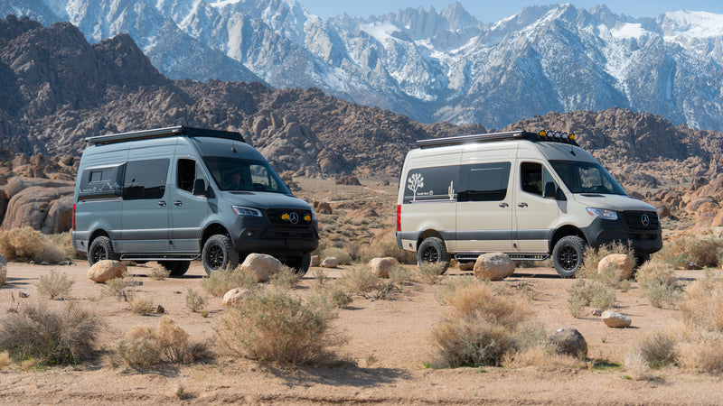 Two custom Sprinter rv rental vans (grey & beige) in a rocky desert, backed by snowy mountains. Perfect for adventure. — photo 9