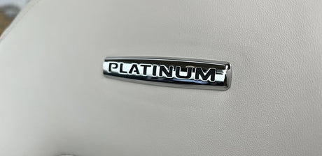 Luxurious 'PLATINUM' emblem on a light, textured interior surface, suggesting a premium rv rental experience.
