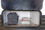 RV rental storage with a black utility bag and stacked organizer boxes inside a side compartment, ready for travel.