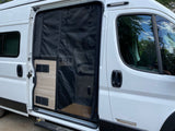 A white Winnebago RV rental with an open side door and bug screen, showing interior and exterior details.