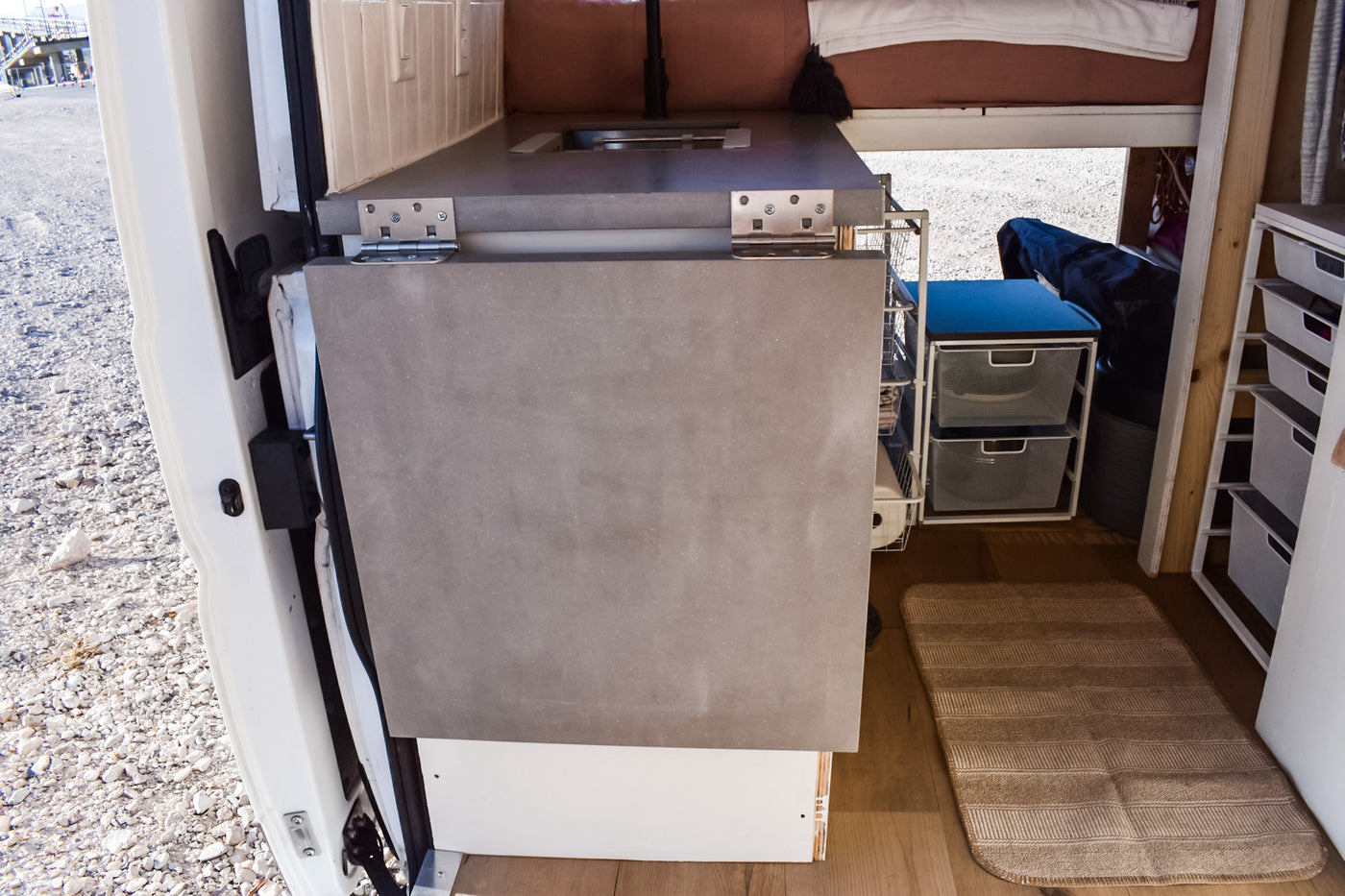 Inside this RV rental: a compact camper van interior with a fold-down counter, sink, and clever storage solutions. — photo 20
