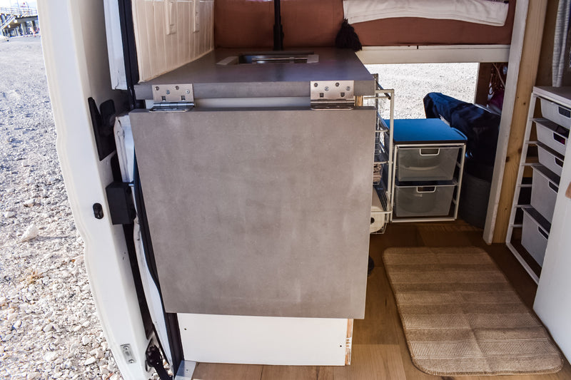 Inside this RV rental: a compact camper van interior with a fold-down counter, sink, and clever storage solutions. — photo 20