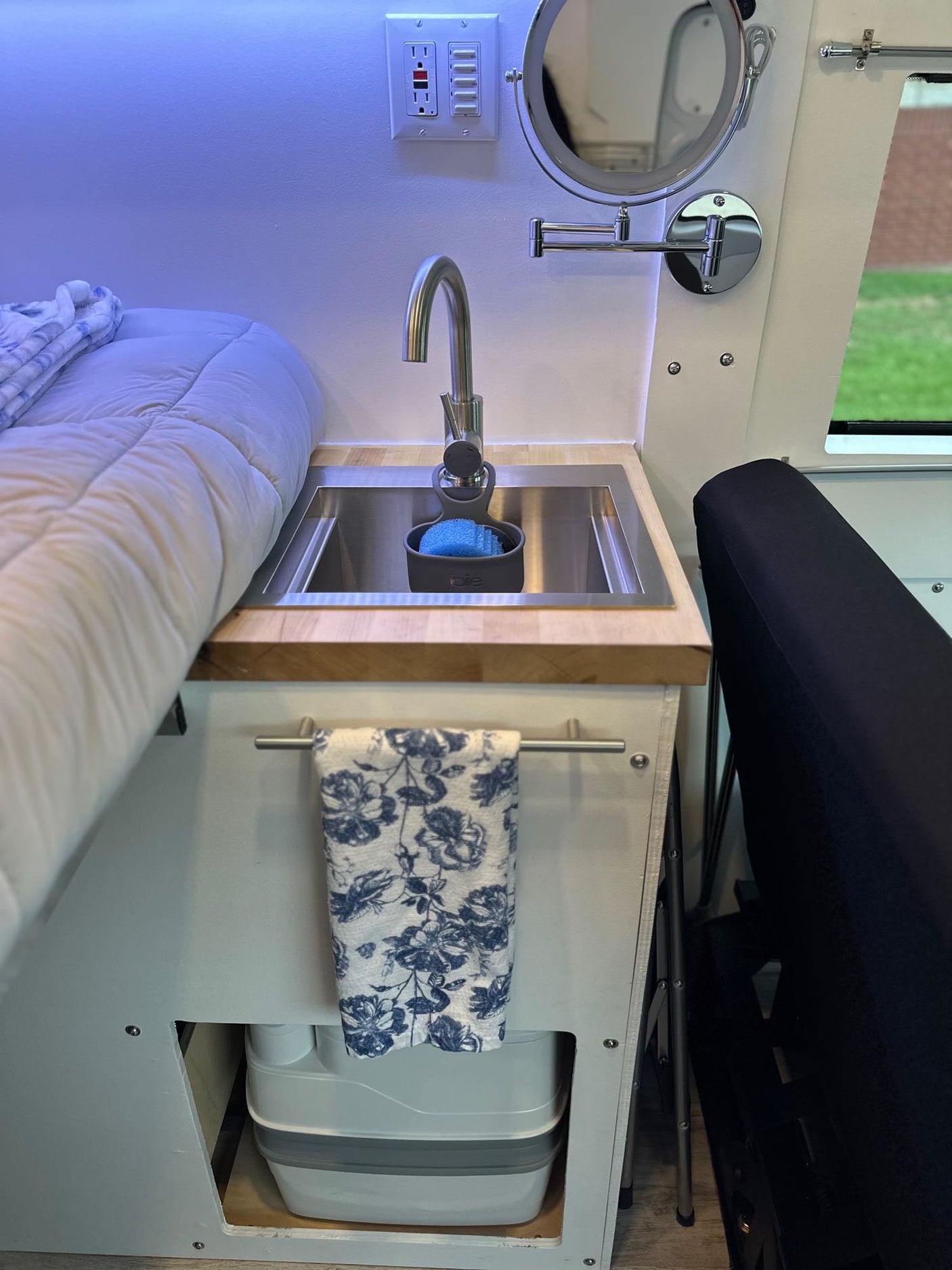 Inside an RV rental: compact kitchen sink, cozy bed, and a cleverly concealed portable toilet maximize small space living.