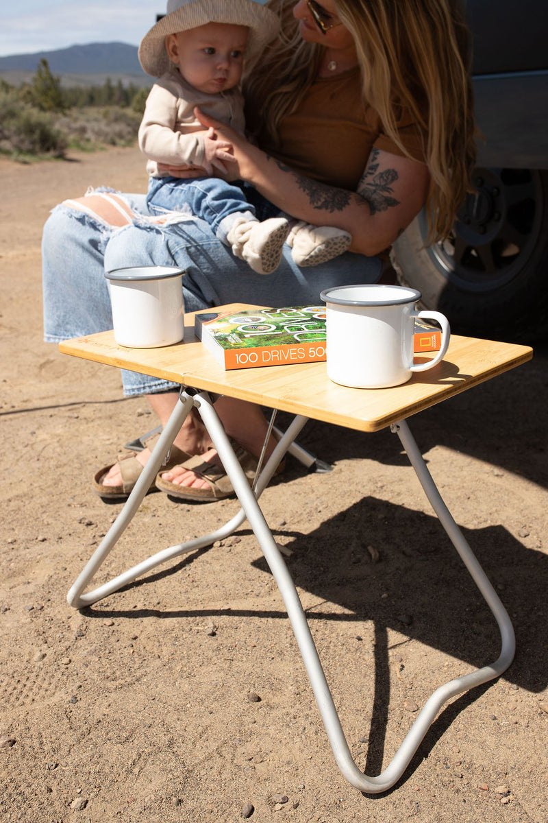  a woman holds a baby inside.|A family with a baby enjoys a relaxing day outside their white Mercedes Sprinter RV rental — photo 3