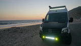 This Mercedes Sprinter RV rental shines bright on a sandy beach at sunset, perfect for coastal camping adventures.