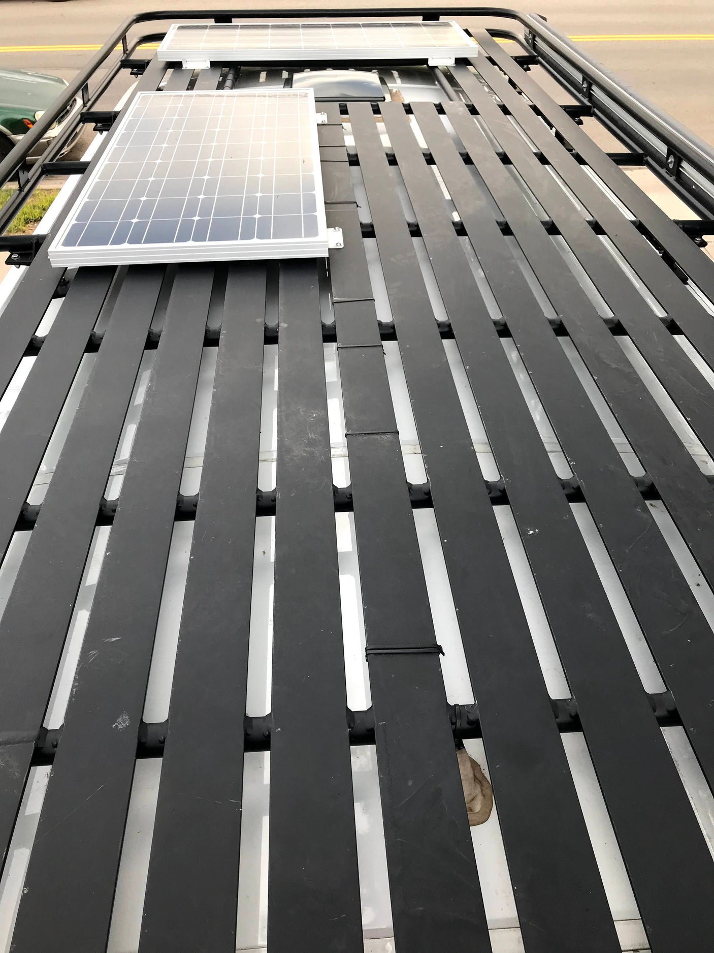 Top-down view of an RV rental roof rack with two tilted solar panels, perfect for off-grid power on the road.