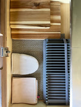 RV rental kitchen drawer: Organized wood cutting boards, hand ironing board, waffle towel, and slatted drying rack.