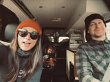 A happy family of three smiles in their cozy RV rental camper van, ready for their road trip.