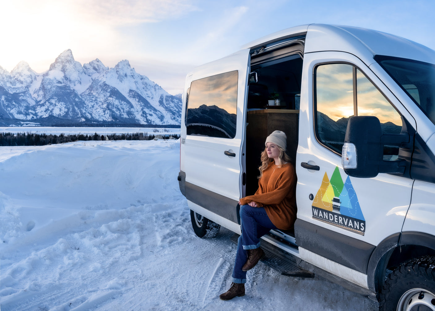 WANDERVANS RV rental van, woman enjoys snowy mountain views. Perfect for winter travel.