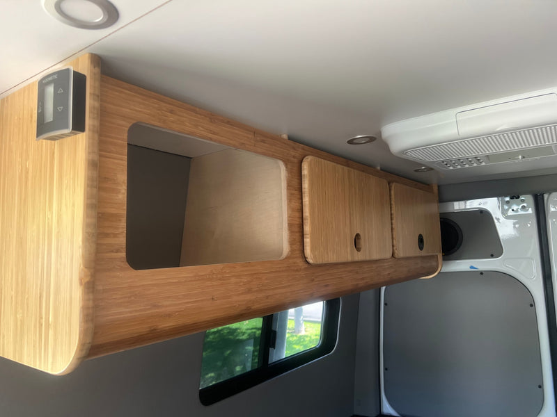 Stylish bamboo overhead storage cabinets with a Dometic control panel on the left, visible in this RV rental's interior. — photo 12