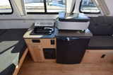 Explore a compact **RV rental** kitchen area featuring a sink, refrigerator, and comfortable bench seating.