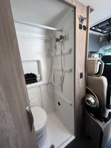 This RV rental features a compact, integrated wet-bath with a shower, toilet, and convenient storage for your adventure.