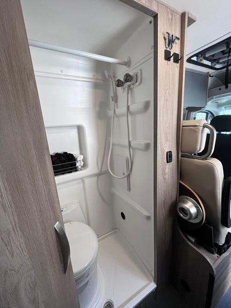 This RV rental features a compact, integrated wet-bath with a shower, toilet, and convenient storage for your adventure.