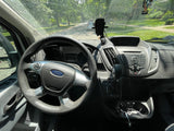 Interior view of a Ford Transit van, common for commercial or rv rental conversions. Driver's perspective of dashboard & street.
