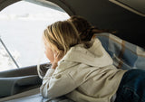 Child and adult relaxing in their RV rental, enjoying the window view.