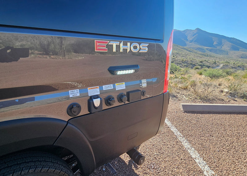  featuring a Thule awning. An ideal RV rental for your next outdoor adventure.|Modern Ethos RV rental with utility hookups parked in a sunny desert landscape — photo 6