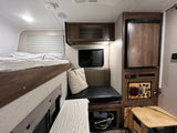 Cozy RV rental interior with bunk bed, dinette, compact fridge, and a custom power management display.